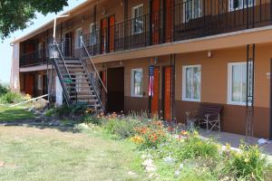 ein Gebäude mit Treppen und Blumen davor in der Unterkunft Budget Host Sundowner Motor Inn Kadoka in Kadoka