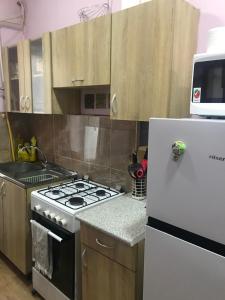 a kitchen with a stove and a white refrigerator at Дом Кети в туристическом районе Тбилиси-авлабари in Tbilisi City