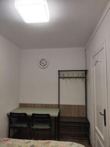 une chambre avec une table, deux chaises et une horloge dans l'établissement Habitación acogedora matrimonial, à Olesa de Montserrat