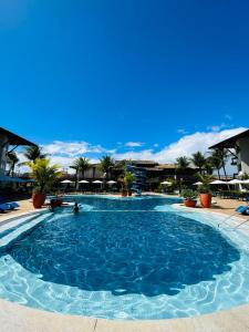 een groot zwembad met palmbomen op de achtergrond bij Hotel Aldeia da Praia in Ilhéus
