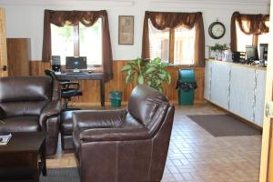 uma sala de estar com cadeiras de couro e uma mesa em Budget Host Sundowner Motor Inn Kadoka em Kadoka