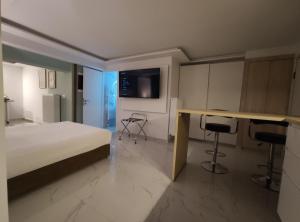 um quarto com uma cama, uma secretária e uma televisão em Athens Stay 40 em Atenas