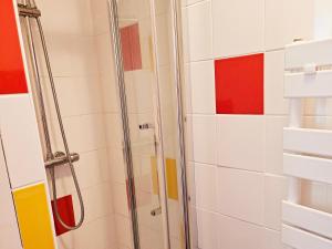 y baño con ducha y azulejos rojos y blancos. en maison a côté du port et du centre, en La Turballe 6 fotos más