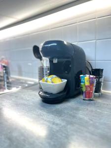 a coffee maker on a counter with a bowl of fruit at Hypercentre Evry Appartement équipé avec Parking inclus in Courcouronnes