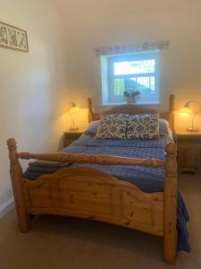 um quarto com uma cama de madeira e uma janela em Stunning Barn Conversion next to Horse Field sleeps 10 em Morpeth