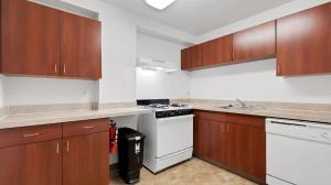 een keuken met houten kasten en een witte kookplaat bij Corporate 1br Suite, Pool, Free Parking, Gym Pp in Harrisburg