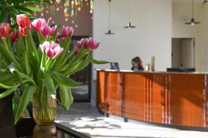 un jarrón lleno de flores rosas sentado en una mesa en Grand Hôtel Du Parc - Teritoria, en Aix-les-Bains