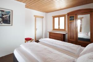 1 dormitorio con 2 camas y techo de madera en Casa Bubeck en Cavagnago