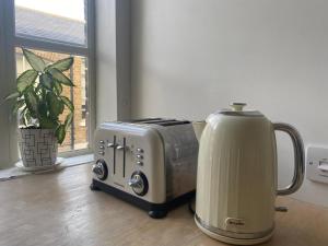 a toaster and a toaster sitting on a table at Bright and peaceful mews flat in London