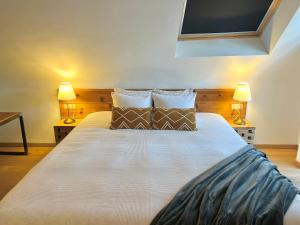 een slaapkamer met een groot bed met 2 lampen bij Villa Mosan Bord de Meuse - Mes Caprices B&B in Namen