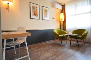 - une salle d'attente avec deux chaises et une table dans l'établissement Parkhotel Brunauer, à Salzbourg