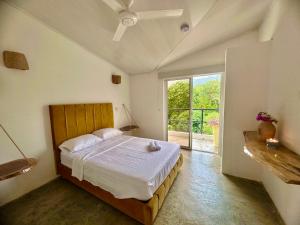 a bedroom with a bed and a large window at Tayrona Angel Lodge in El Zaino