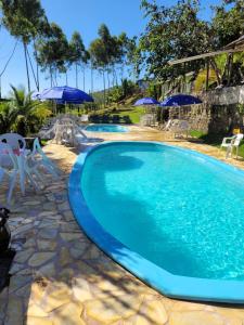 a large swimming pool with chairs and umbrellas at Refugio de Itamambuca in Ubatuba