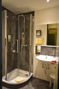 een badkamer met een douche en een wastafel bij Parkhotel Brunauer in Salzburg