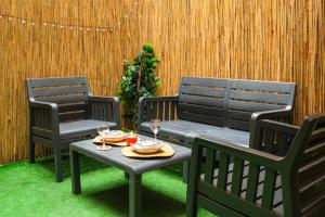 eine Terrasse mit 2 Stühlen und einem Tisch mit Weingläsern in der Unterkunft Taksim Nikea Suites 80 in Istanbul