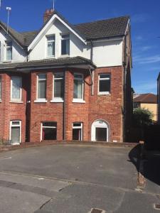 a brick house with a parking lot in front of it at Spacious 5 Large Bedroom Victorian House - Beach 2 Miles in Parkstone