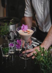 Eine Person hält einen Martini mit einer Blume auf einem Tisch. in der Unterkunft Maharìa in Menfi
