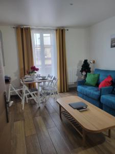 a living room with a blue couch and a table at Amazing apartment a stone's throw from the City of Lights - Paris in Clichy