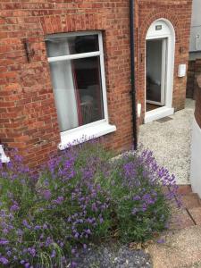 a brick building with windows and purple flowers at Spacious 5 Large Bedroom Victorian House - Beach 2 Miles in Parkstone
