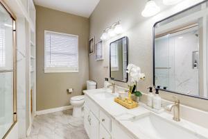 un bagno con lavandino, WC e specchio di Hello There a Corpus Christi Altre 13 foto