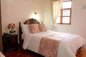 Schlafzimmer mit einem Bett und einem Fenster in der Unterkunft Rincón Familiar Hostel Boutique in Quito