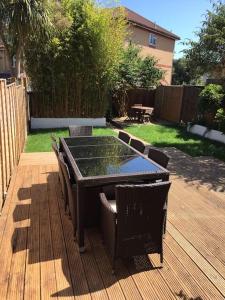 a patio with a table and chairs on a deck at Spacious 5 Large Bedroom Victorian House - Beach 2 Miles in Parkstone