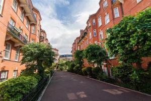 an empty street between two tall brick buildings at Spacious Flat in West Kensington in London
