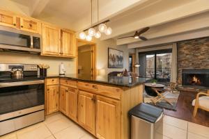 une cuisine avec des armoires en bois et une cheminée dans l'établissement Lodge at Lake Dillon Condo: Great Year-Round Location, à Dillon 26 autres photos