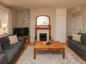a living room with a couch and a coffee table at Jasmine Cottage in Alnwick