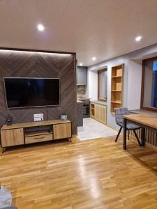 een woonkamer met een grote televisie en een tafel bij Sofi Apartment in Võru