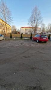 a red car is parked in a parking lot at Sofi Apartment in Võru