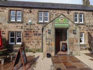a building with a sign that reads white covenant inn at Rose Cottage in Alnwick