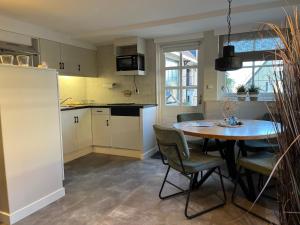 a kitchen and dining room with a table and chairs at It Bûthús in Baaiduinen