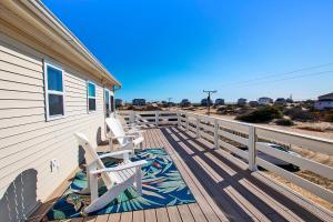 a deck with two chairs and a house at Oceanside, Wild Horses! Beach getaway, remote location, 4x1701, Sandy Paws Retreat in Corolla