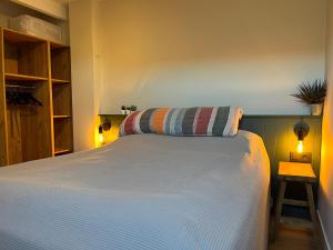 1 dormitorio con 1 cama blanca grande y 2 luces en It Bûthús, en Baaiduinen