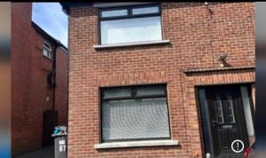 a brick building with two windows and a door at Belfast Mac -Double Room shared bathroom in Belfast