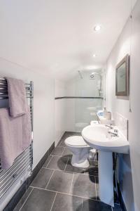 a bathroom with two toilets and a sink at The Scarsdale Apartment in Doncaster