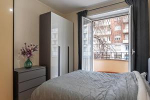 a bedroom with a bed and a large window at Piazzale delle Provincie Apartment in Rome