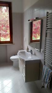 a white bathroom with a sink and a toilet at Guest House San Francesco Garden in Rapolano Terme