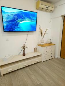Una sala de estar con un televisor de pantalla plana en la pared. en The Bohemian Connection, Rezerva acum studio Ultracentral Spatios si Curat, Scaun Masaj, Ceai, cafea, apa filtru, parcare publica gratuita, en Craiova