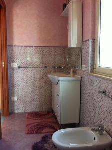 een badkamer met een wastafel en een toilet bij Villetta Pergole in Realmonte