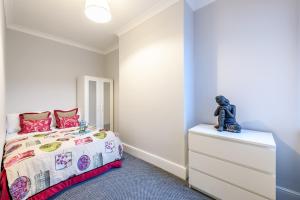 a small bedroom with a bed and a dresser at The Scarsdale Apartment in Doncaster