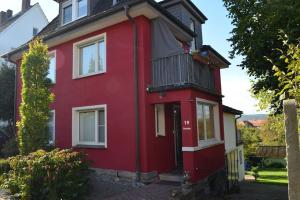 ein rotes Haus mit einem Balkon in der Unterkunft Ruhige Ferienwohnung im Grünen in Arnsberg