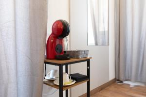 泰拉奇納的住宿－Luxury Suite - Teatro Romano - Duomo - Centro Storico Wi-Fi，坐在一个房间里桌子上的红色器具