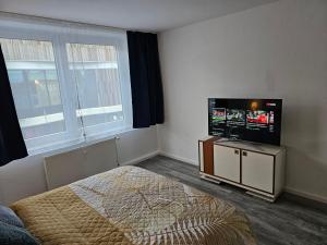 Schlafzimmer mit einem Bett und einem Flachbild-TV in der Unterkunft Chris Home - Mönchengladbach Minto in Mönchengladbach