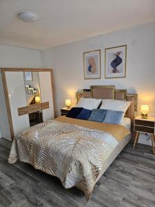 ein Schlafzimmer mit einem großen Bett mit zwei Tischen und zwei Lampen in der Unterkunft Chris Home - Mönchengladbach Minto in Mönchengladbach