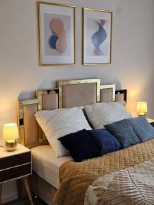 ein Schlafzimmer mit einem Bett mit drei Bildern an der Wand in der Unterkunft Chris Home - Mönchengladbach Minto in Mönchengladbach