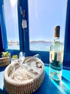 a bottle of wine sitting next to a basket with a bottle of glass at mills suites mykonos in Mikonos
