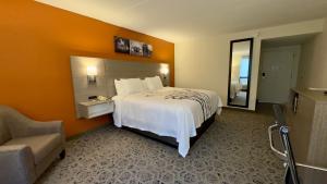 a hotel room with a large bed and a chair at Sleep Inn Chambersburg in Chambersburg +4 photos