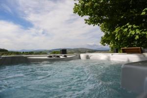 a jacuzzi tub with a view of the mountains at Lomond View in Langbank